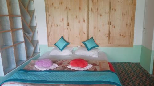 - une chambre avec un lit et 2 poupées dans l'établissement Summer and winter homestay Turtuk Youl, à Turtok