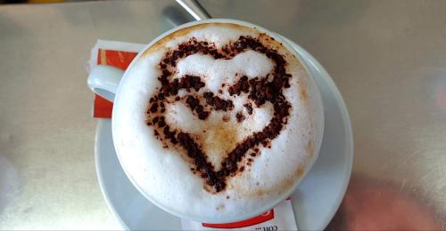 a cup of coffee with two hearts painted on it at Amalfi Rooms Duoglio Beach -amazing seaview in Amalfi