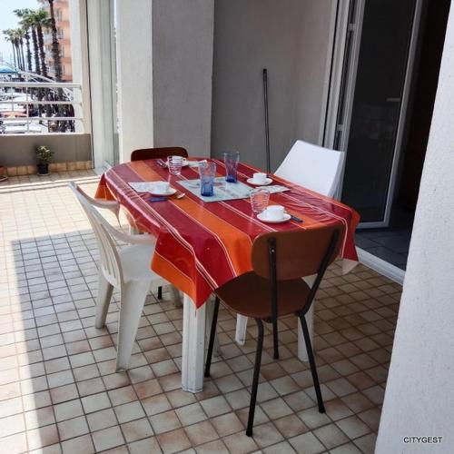 une table avec des chaises et un tissu de table rouge dans l'établissement Appartement T3 proche commerces et animations - 5CDUSUD1, à Canet
