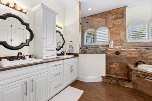 a white bathroom with two sinks and a shower at Marco Island's Delight in Marco Island