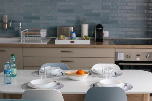 een keuken met een tafel met stoelen en een kom sinaasappels erop bij Cocon d'Hiver - Netflix & Wifi - Parking Gratuit - check-in 24H24 - Kit Bébé Inclus - GoodMarning in Châlons-en-Champagne