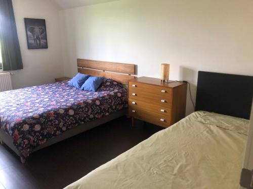 a bedroom with two beds and a dresser and a bed at landelijke villa met zwembad en gezellige openhaard in Zemst