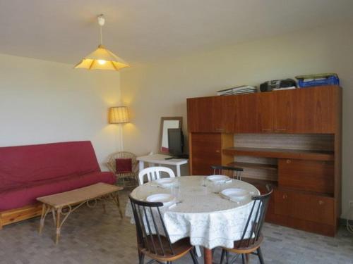 un salon avec une table et un canapé rouge dans l'établissement Appartement face Mer, idéal famille 6NOUM12 sea view 2 bedrooms apartment, à Canet