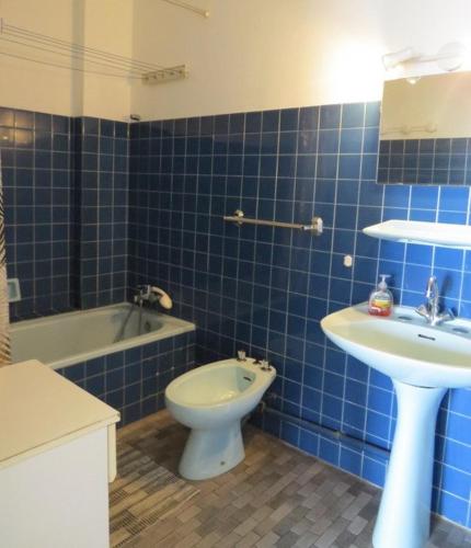 La salle de bains est pourvue de carrelage bleu, de toilettes et d'un lavabo. dans l'établissement Appartement face Mer, idéal famille 6NOUM12 sea view 2 bedrooms apartment, à Canet