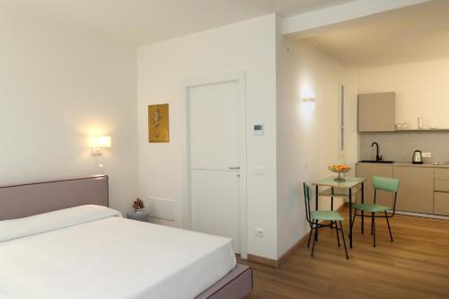 Ancora Suites في باردولينو: غرفة نوم بسرير وطاولة وكراسي