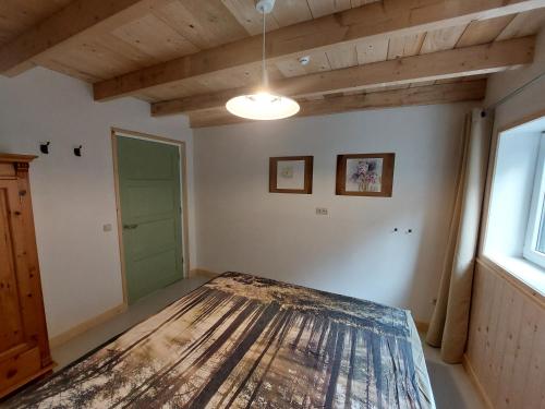 Habitación con cama y techo de madera. en Huisjedelinde en Wolvega
