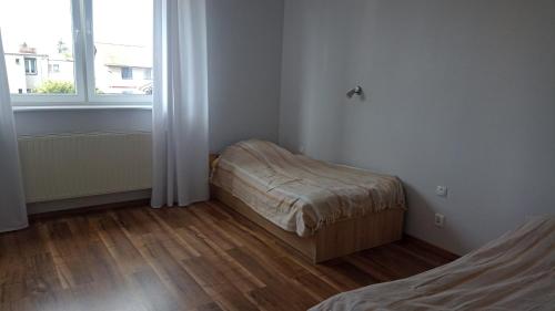 a small room with a bed and a window at Apartament Słoneczny in Poznań