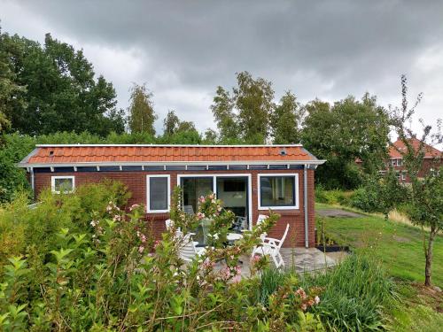 a small red brick house in a garden at Huisje de Linde in Wolvega