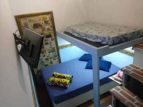 a room with a bunk bed and a television at Suíte Garden in Praia Grande
