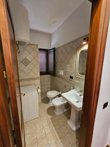 a bathroom with a toilet and a sink at Case Magliolo in Cefalù
