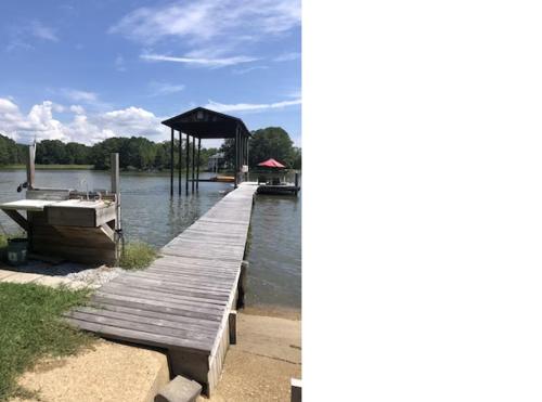 ein Holzsteg mit einem Boot auf dem Wasser in der Unterkunft Waterfront Guest House in Quiet Setting 