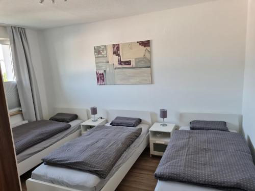 - une chambre avec 2 lits et 2 tables dans l'établissement Wohnung in Herne, à Herne