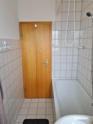 La salle de bains est pourvue de toilettes et d'une porte en bois. dans l'établissement Wohnung in Herne, à Herne