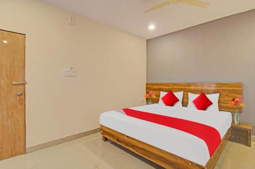 a bedroom with a large bed with red pillows at Flagship Hotel R Square in Warangal