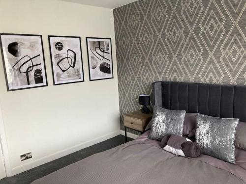 a bedroom with a bed with pictures on the wall at Haymons Cove in Eyemouth