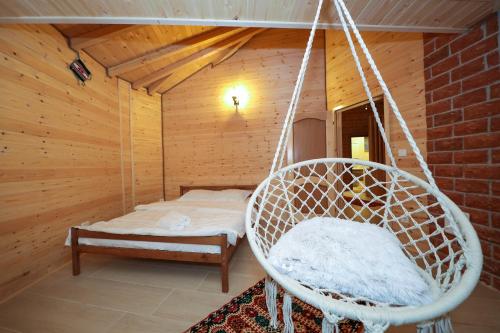 a swinging chair in a room with a bed at MALËSIA EKO RESORT in Peje