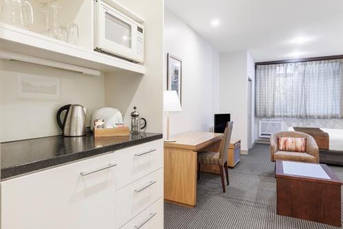 a kitchen and living room with a desk and a bed at Adina Citylife Wellington in Wellington