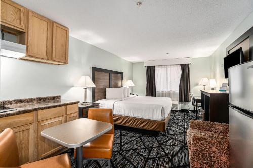 a hotel room with a bed and a kitchen at Baymont by Wyndham Grand Haven in Grand Haven