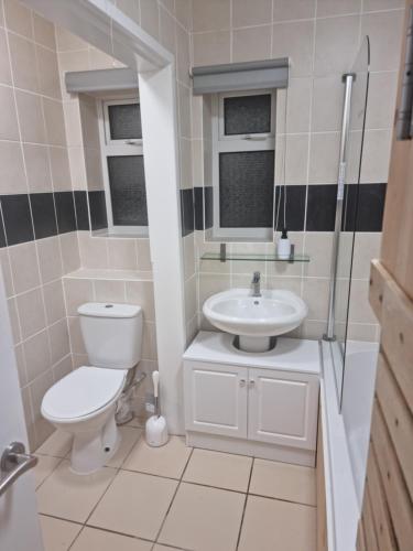 a bathroom with a toilet and a sink at Cozy Nook in Gristhorpe