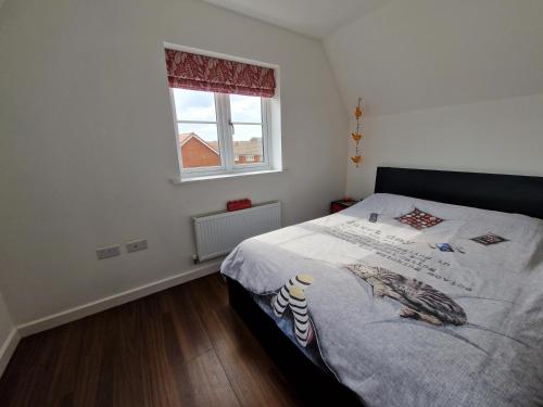 a small bedroom with a bed with a window at Spacious 3 bedroom family home in Shinfield
