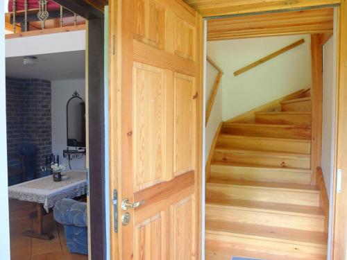 an open door leading into a room with stairs at Chata w lesie in Zagwiździe
