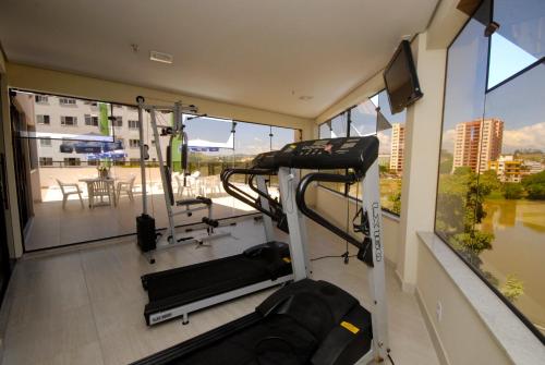 een kamer met een fitnessruimte en uitzicht op een balkon bij River Park Hotel in Resende