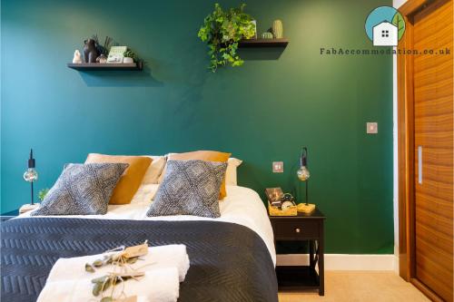 a bedroom with a bed and a green wall at Amazing Flat-Parking available-By FabAccommodation in Cardiff