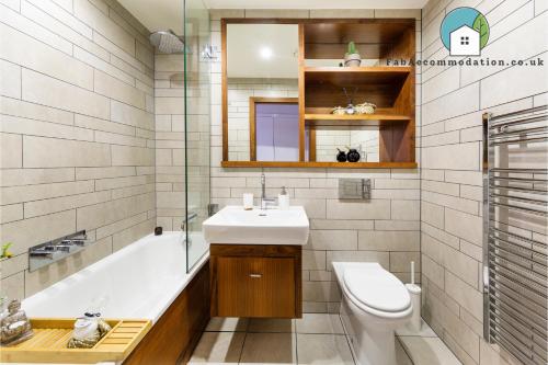 uma casa de banho com um lavatório, uma banheira e um WC. em Amazing Flat-Parking available-By FabAccommodation em Cardiff