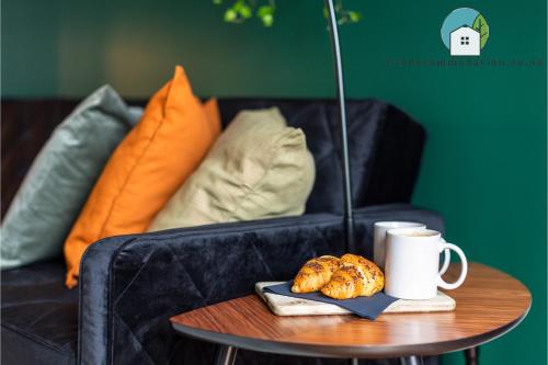 a coffee table with a plate of croissants and a cup of coffee at Amazing Flat-Parking available-By FabAccommodation in Cardiff