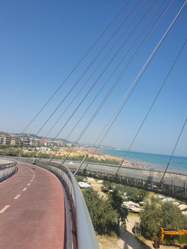 un pont suspendu sur une route à côté de l'océan dans l'établissement Margherita 64, à Pescara