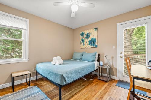 a bedroom with a bed with a blue comforter at 2 Bed Townhouse: Minutes from DCA-National Airport in Alexandria