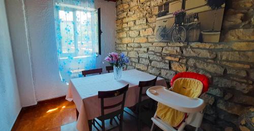 comedor con mesa y pared de piedra en HABITACIONES PRIVADAS - CASA RURAL - Baño compartido con los anfitriones en Suances