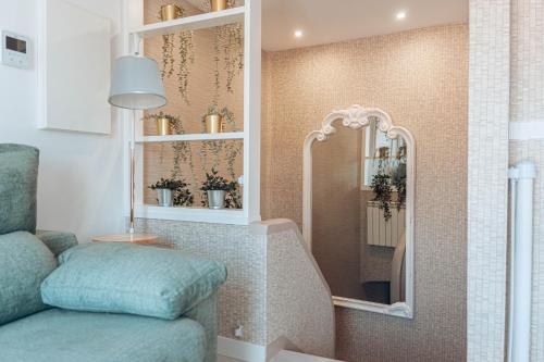 ein Wohnzimmer mit einem Stuhl und einem Spiegel in der Unterkunft Apartamentos La Moneda in Burgos