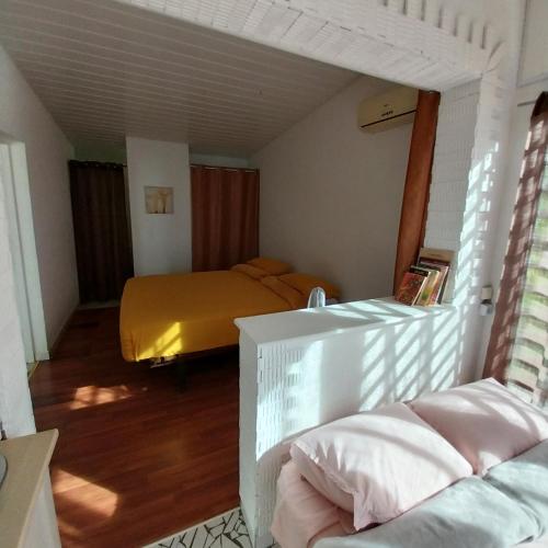 1 dormitorio con 1 cama con manta amarilla en Pacific Lodge, en Mahina