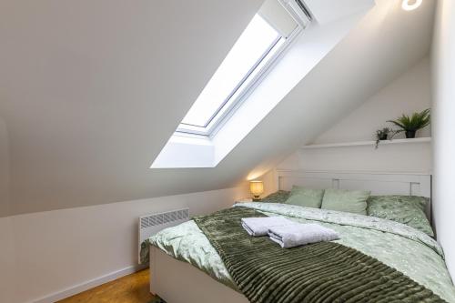 ein Schlafzimmer mit einem Bett und einem Dachfenster in der Unterkunft Attic Apartment with Peaceful view + Parking in Prag
