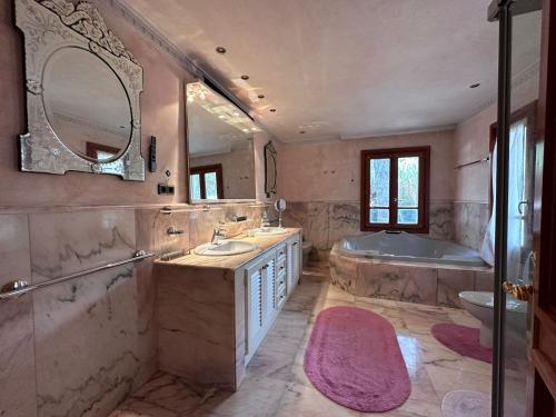 uma grande casa de banho com uma banheira e um lavatório e uma banheira em Casa Cabopino em Marbella