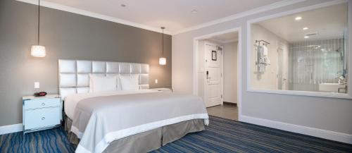 a bedroom with a large bed and a bathroom at Woodcrest Hotel in Santa Clara