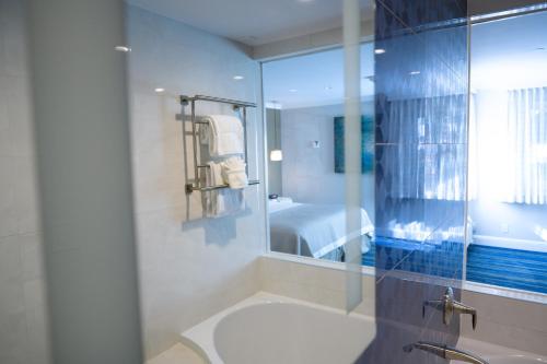 a bathroom with a shower and a sink and a mirror at Woodcrest Hotel Cupertino in Santa Clara