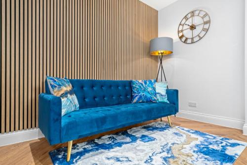 a blue couch in a living room with a rug at Stylish 4 Bed-Town Centre in Galashiels