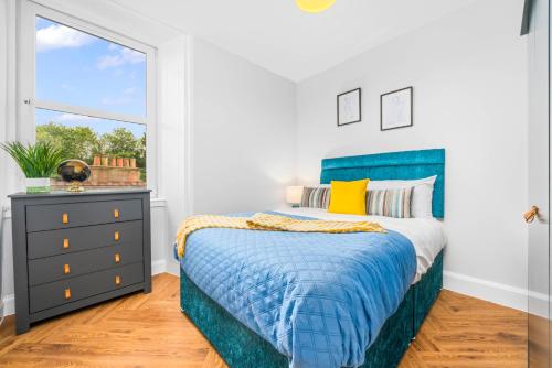 Stylish 4 Bed-Town Centre في غالاشيلز: غرفة نوم بسرير ازرق ونافذة