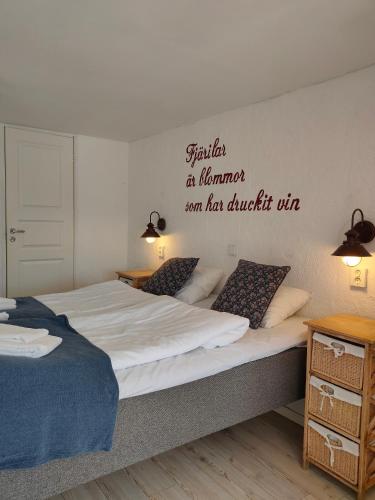 a bedroom with two beds and a sign on the wall at Vingården i Arild in Arild