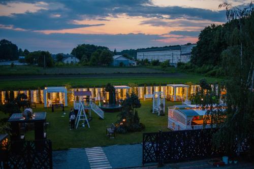 einen Hinterhof mit vielen Zelten und einem Spielplatz in der Unterkunft Кузня міні-готель in Mateyevtsy