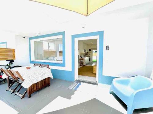 sala de estar con mesa y pared azul en Casa de Praia - Almograve en Almograve
