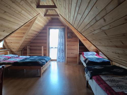 a attic room with three beds and a window at Pokoje u Joanny in Ząb