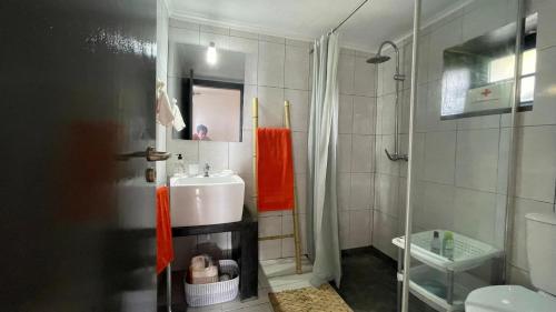W łazience znajduje się umywalka i prysznic. w obiekcie Pé Direito w mieście Faja Grande
