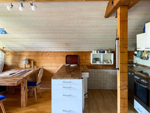 eine Küche mit einem Tisch und einer Holzwand in der Unterkunft Ammergauer Ferienidyll in Unterammergau