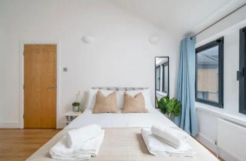 1 dormitorio blanco con 1 cama blanca grande con almohadas en Penthouse, en Luton