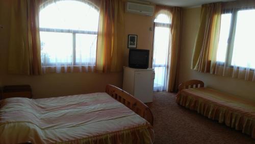 クラネヴォにあるStefan Family Hotelのベッド2台、テレビ、窓が備わる客室です。