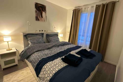 a bedroom with a large bed with a window at Appartement Cozy - Quartier résidentiel in Melun