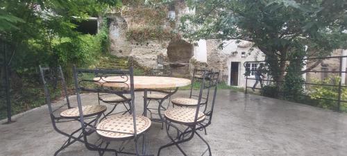 una mesa y cuatro sillas, una mesa y un edificio en Troglo entre Caves et Châteaux en Montlouis-sur-Loire